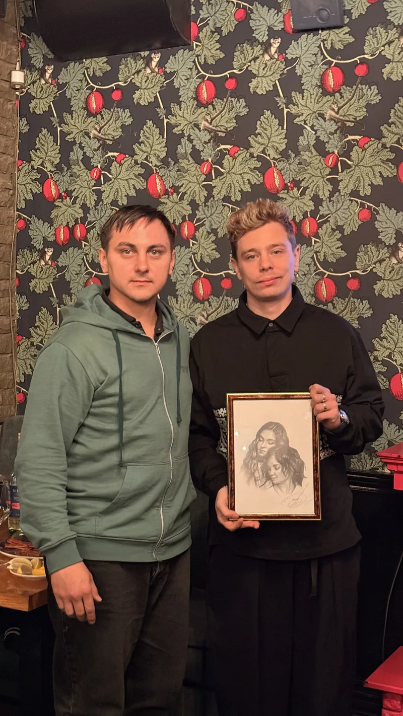 Художник Айнур Тимергалиев вручает портрет «Две сестры» стендап-комику Сергею Орлову